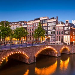 Pretty dutch doll houses illuminated and reflected along the tranquil canals of Amsterdam.