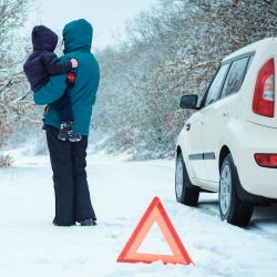 woman with a child on the winter road. emergency sign