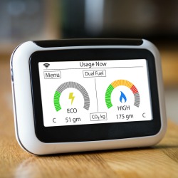 Domestic Energy Smart Meter on a Kitchen Worktop Displaying Electric and Gas Carbon Emissions in Real Time