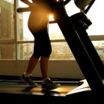 Young asian woman exercising on a treadmill