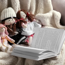 Rag dolls with fairy tales book on bedspread. Childhood concept