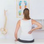 rear view of patient with back pain in medical office